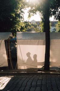 Shadows of people appear on a white backdrop.
